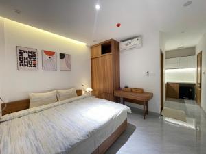 a bedroom with a large white bed and a table at Sò homestay in Thôn Văn Dương
