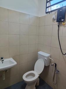 a bathroom with a toilet and a sink at Rumah SK in Batu Kurau +7 photos
