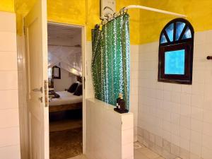 a bathroom with a shower curtain and a bedroom at Casa Hera Diani in Diani Beach +63 photos