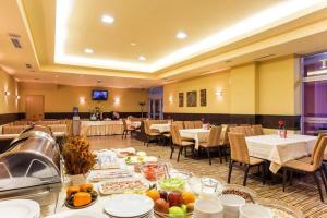 a restaurant with tables and chairs with food on them at Edelweiss Mountain Apartment - Stream Resort Spa & Pool, Pamporovo in Pamporovo
