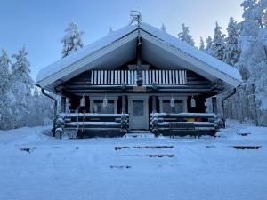 eine kleine Blockhütte mit Schnee auf dem Boden in der Unterkunft Vaaranpää in Kotaniemi