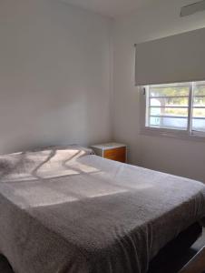 a white bedroom with a bed and a window at Quinta don josé in Luján