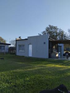 a small white house with a grass yard at Quinta don josé in Luján