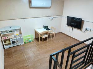 a room with a small table and a tv in a room at Rumah SK in Batu Kurau