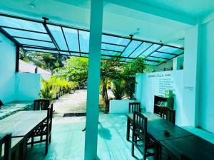 a patio with a table and chairs and a view of a street at Surf Bay Hotel in Arugam Bay