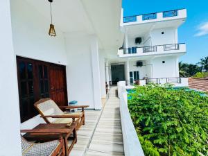 a balcony of a house with two chairs and a table at Surf Bay Hotel in Arugam Bay