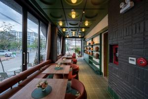 a row of tables in a restaurant with windows at Olwen Boutique Hotel in Danang
