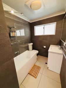 a bathroom with a tub and a toilet and a sink at Esperance Seaside Cottage in Esperance +25 photos