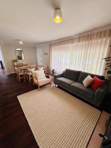 a living room with a couch and a table at Esperance Seaside Cottage in Esperance
