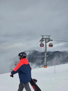a person on a snowboard in the snow next to a ski lift at Guest House Nukri in Danisparauli +14 photos