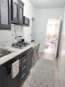 a kitchen with black cabinets and a counter top at Cozy Apartamento en Puebla! in San Baltasar