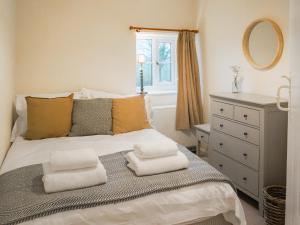 a bedroom with a bed with towels on it at Corbetts Lodge Cottage in Swaffham