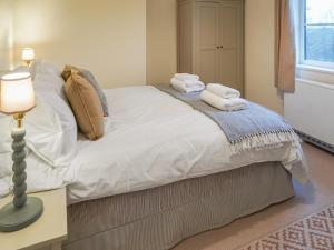 a bedroom with a bed with towels on it at Corbetts Lodge Cottage in Swaffham