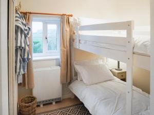 a bedroom with a bunk bed and a window at Corbetts Lodge Cottage in Swaffham