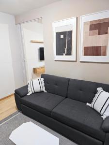 a black couch in a living room with two pillows at Cozy Apartamento en Puebla! in San Baltasar