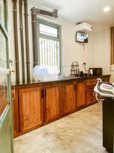 a kitchen with wooden cabinets and a sink at Barren House in Hiriketiya