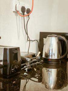 a tea kettle and toaster sitting on a counter at Barren House in Hiriketiya