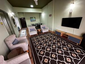 a living room with a flat screen tv and a couch and chairs at The Regency PortDickson A1-7 in Port Dickson