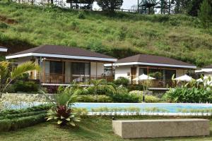 a house with a swimming pool in front of a hill at Kenjelo Farm and Recreation Resort in Dullan +22 photos
