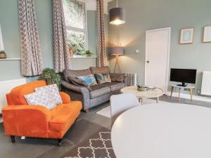 a living room with an orange chair and a couch at Ferndale in Lynton