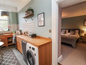 a kitchen with a washing machine in a room with a bed at Ferndale in Lynton +3 photos