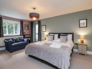 a bedroom with a large bed and a blue chair at Ferndale in Lynton