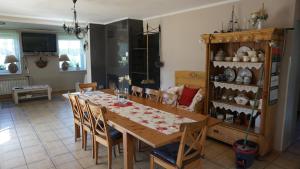 a dining room with a wooden table and chairs at DOM NAD JEZIOREM KUŹNIa in Łąkie +32 photos