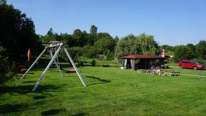 a park with a swing set and a picnic shelter at DOM NAD JEZIOREM KUŹNIa in Łąkie