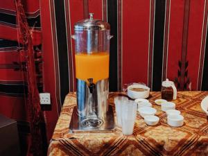 a blender sitting on a table with orange juice at Rocky Mountain Hotel Jordan in Petra