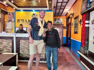 two men are posing for a picture in a restaurant at Shangrila Boutique Hotel in Kathmandu