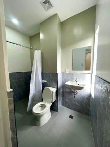 a bathroom with a toilet and a sink at Lagkaw Ekonotel in Dipolog