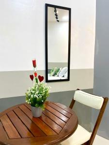a wooden table with a vase of flowers and a mirror at Lagkaw Ekonotel in Dipolog