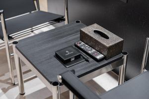 a table with a remote control and a box on it at 구미 더혜밀호텔 in Gumi