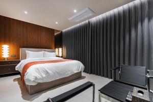 a bedroom with a bed and a desk and a tv at 구미 더혜밀호텔 in Gumi