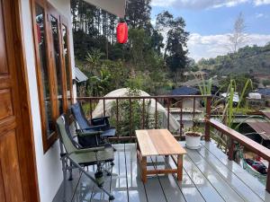 a porch with two chairs and a table on a balcony at บ้านซินอัน in Ban Rak Thai