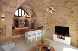 a kitchen with a large stone wall at Dar22 in Fad‘ūs