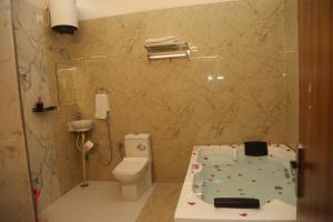 a bathroom with a bath tub and a toilet at The Gold Mount Villa in Udaipur +14 photos