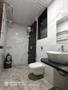 a bathroom with a white toilet and a sink at Vrindavan beach resort in Diveagar
