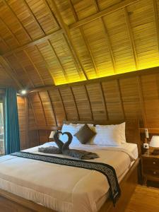 a bedroom with a large bed with a swan on it at Lumbung Intan in Sidemen