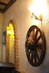a wooden wagon wheel on a wall with a lamp at Millenium Palace in Ohrid