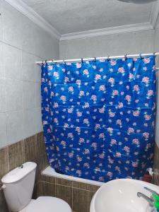 a bathroom with a toilet and a blue shower curtain at الرائد للشقق المفروشة in Amman +34 photos