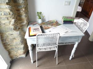 a white table with two chairs and a book on it at Ca Du Ventu in Carbuta