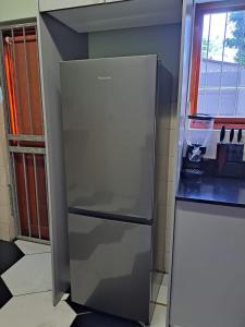 a stainless steel refrigerator in a kitchen next to a window at Capetown Adilo Villa 2 in Cape Town