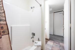 a bathroom with a shower and a toilet and a door at Cozy Studio w/ Partial Lake view #223 at Donner Lake Village in Truckee