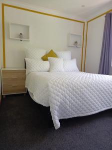 a bedroom with a large bed with white sheets and pillows at Capetown Adilo Villa 2 in Cape Town