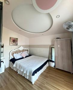 a bedroom with a large bed and a ceiling at Naomi House Phan Thiet in Phan Thiet