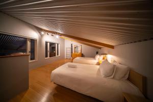 a bedroom with two beds with white sheets at Powdersuites in Hakuba