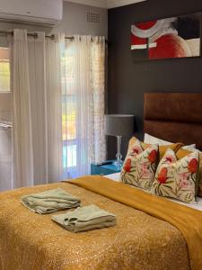 a bedroom with a bed with two towels on it at Amira Boutique Villa in Empangeni