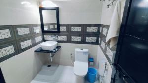 a small bathroom with a toilet and a sink at J P PALACE in Kushinagar +27 photos