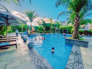 a group of people in a swimming pool with palm trees at Căn hộ tại các tòa ICON40 - ALACARTE - NEW LIFE TOWER in Ha Long